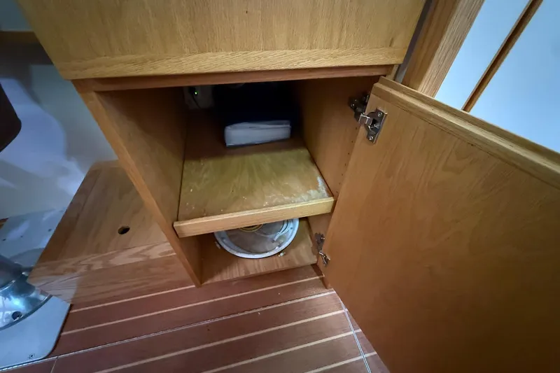 Slide: The Image of Open wooden cabinet in 2013 Eco-Trawler 33, revealing interior storage space. - 36