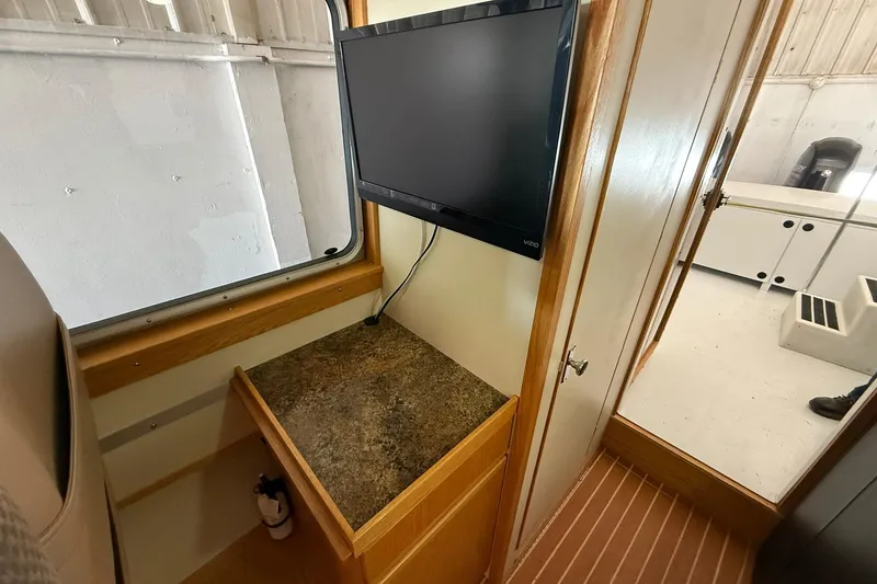 Slide: The Image of Interior of 2013 Eco-Trawler 33 with mounted TV and wooden cabinetry. - 38