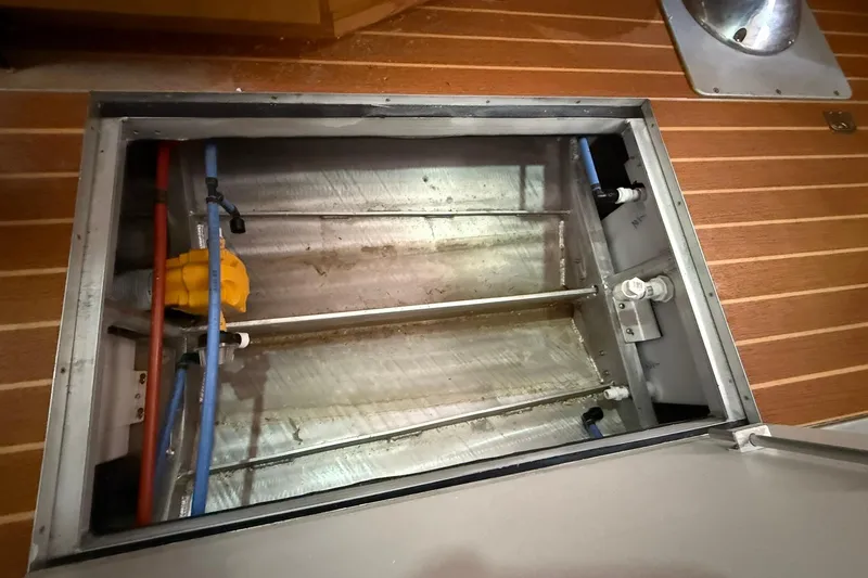 Slide: The Image of Open hatch of 2013 Eco-Trawler 33 showing interior components and piping. - 44