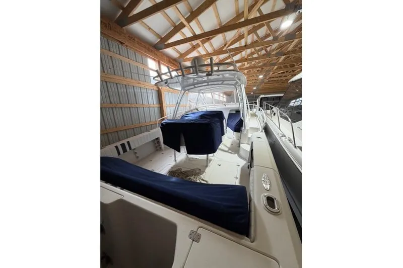 The Image of 2009 Intrepid 377 Walkaround boat in storage, covered seats, wooden ceiling. - 0