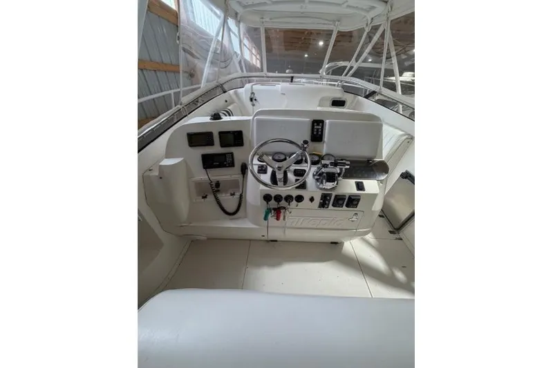 Slide: The Image of 2009 Intrepid 377 Walkaround boat helm with steering wheel and control panel. - 16
