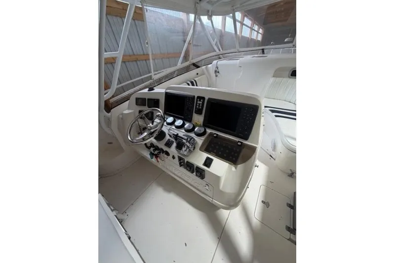 Slide: The Image of 2009 Intrepid 377 Walkaround boat cockpit with steering wheel and control panels. - 23