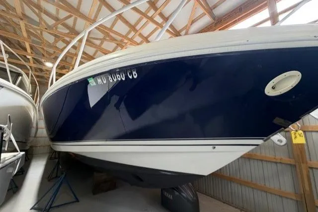 Slide: The Image of 2009 Intrepid 377 Walkaround boat in storage, blue and white hull, indoor facility. - 4