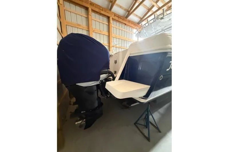 Slide: The Image of 2009 Intrepid 377 Walkaround boat in storage, featuring covered outboard motor. - 6