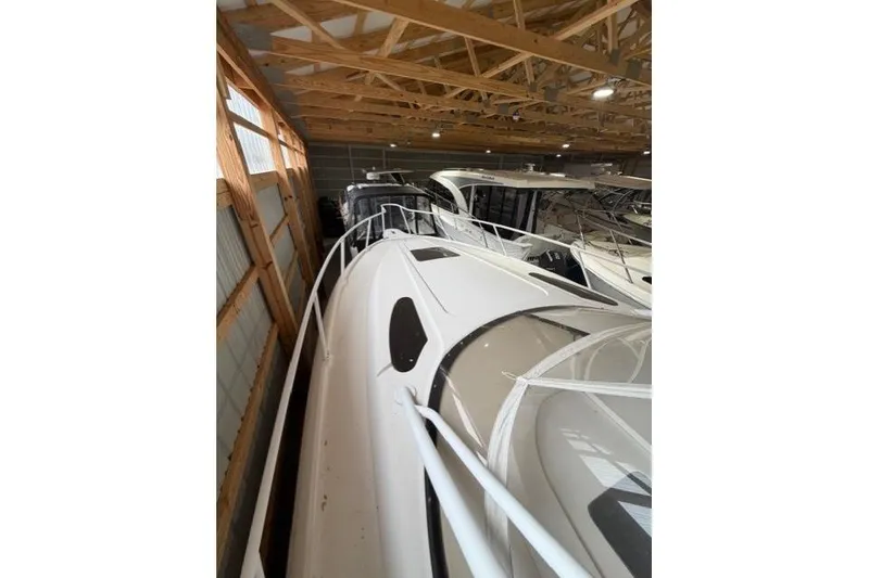 Slide: The Image of 2009 Intrepid 377 Walkaround boat stored indoors, showcasing sleek design and spacious deck. - 7