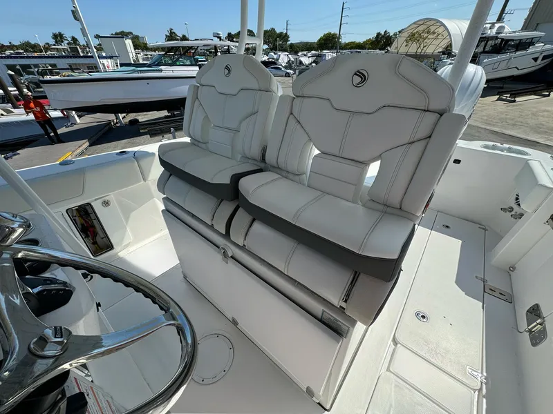 Slide: The Image of 2025 Edgewater 340CC boat interior with dual white cushioned seats and steering wheel. - 11
