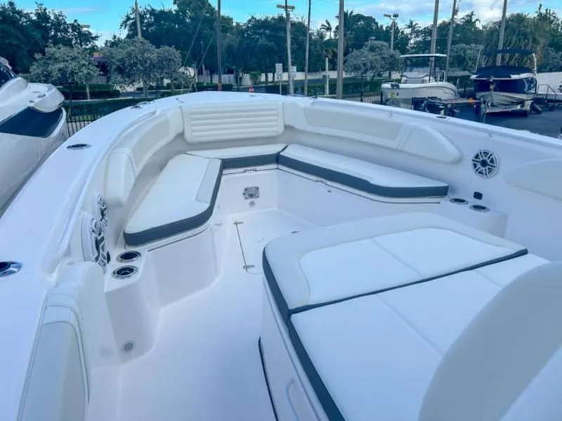 Slide: The Image of 2025 Edgewater 340CC boat interior with white seating and cup holders. - 6