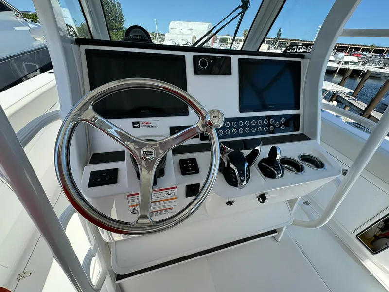Slide: The Image of Edgewater 340CC 2025 boat helm with steering wheel, dual screens, and control panel. - 10