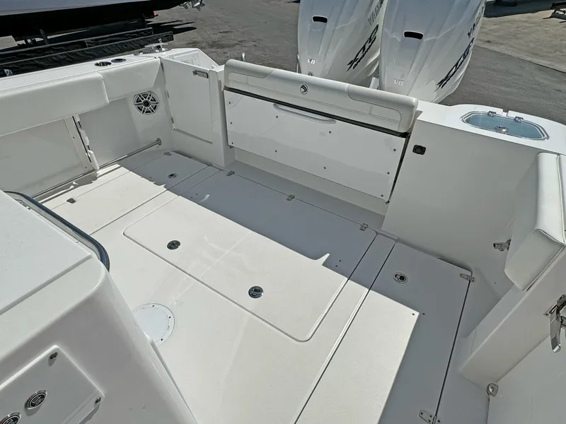 Slide: The Image of 2025 Edgewater 340CC boat deck with dual Yamaha V8 engines, spacious and sleek design. - 16