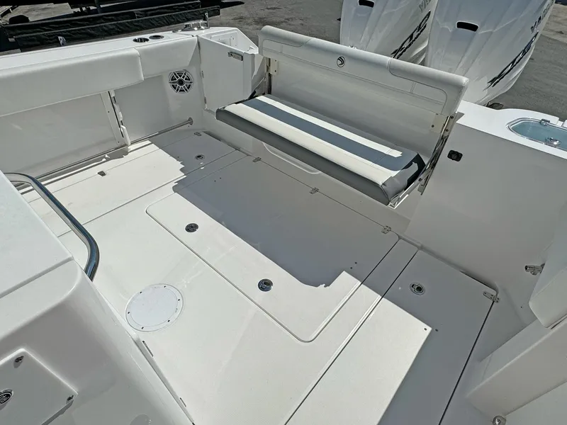 Slide: The Image of 2025 Edgewater 340CC boat deck with foldable seating and twin engines. - 17