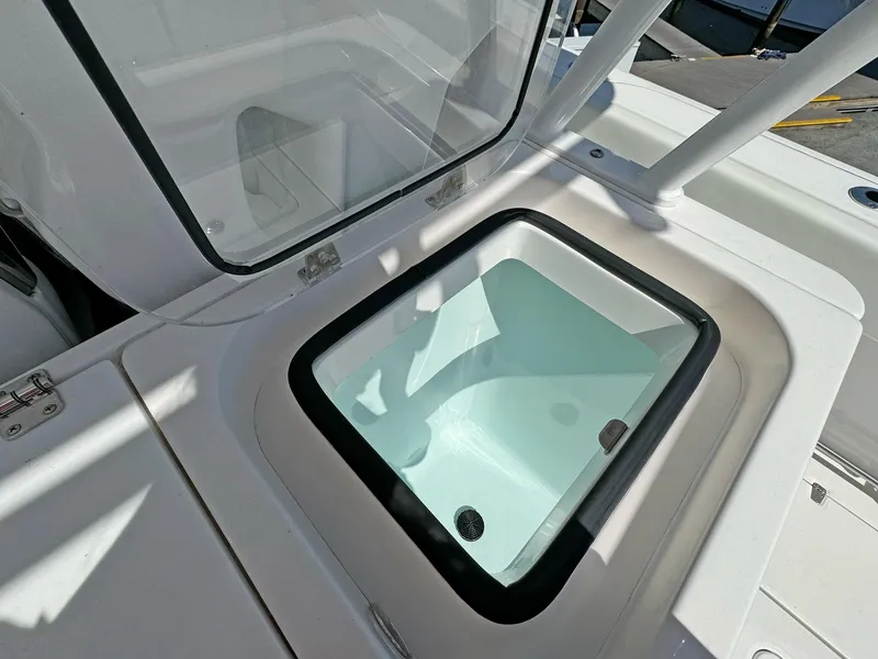 Slide: The Image of Livewell compartment on 2025 Edgewater 340CC boat, open lid, white interior. - 21