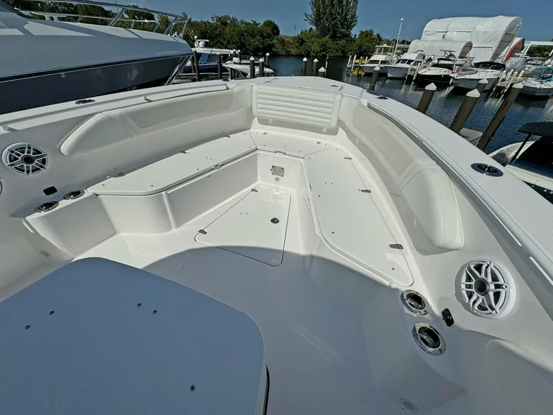 Slide: The Image of 2025 Edgewater 340CC boat interior with spacious seating and modern amenities at a marina. - 5