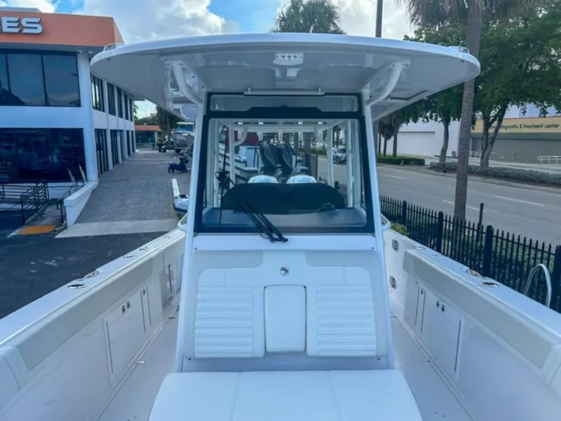 Slide: The Image of Edgewater 340CC 2025 boat, front view at a dealership, showcasing sleek design and spacious deck. - 8