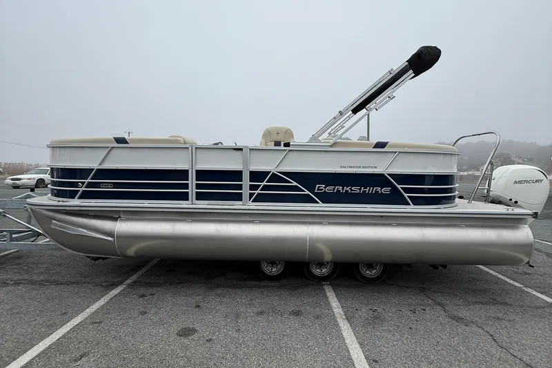 Slide: The Image of 2026 Berkshire 22RFX CTS pontoon boat in parking lot, side view, overcast day. - 5