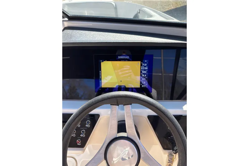Slide: The Image of 2023 Sea Ray SPX 210 Outboard dashboard with Simrad display and steering wheel. - 16