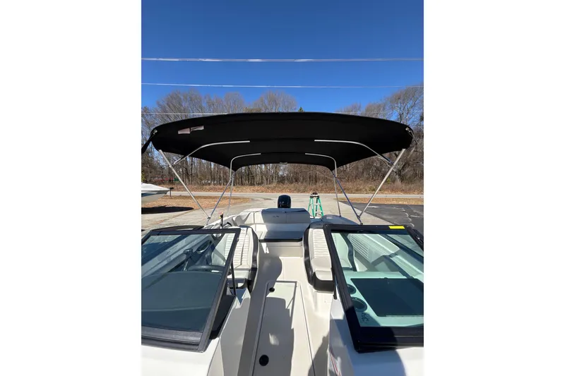 Slide: The Image of 2023 Sea Ray SPX 210 Outboard boat with bimini top under clear blue sky. - 18