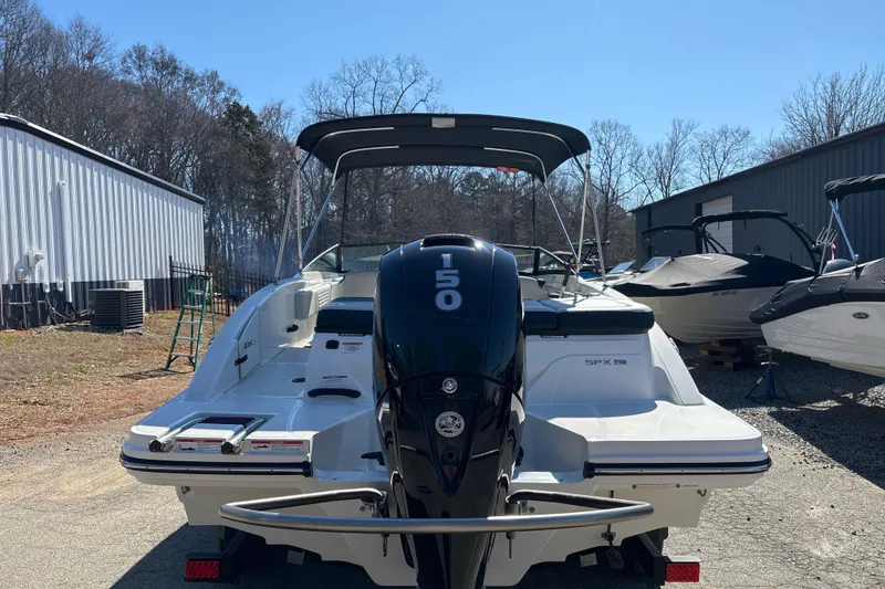 Slide: The Image of 2023 Sea Ray SPX 210 Outboard boat with 150 HP engine, parked outdoors. - 6