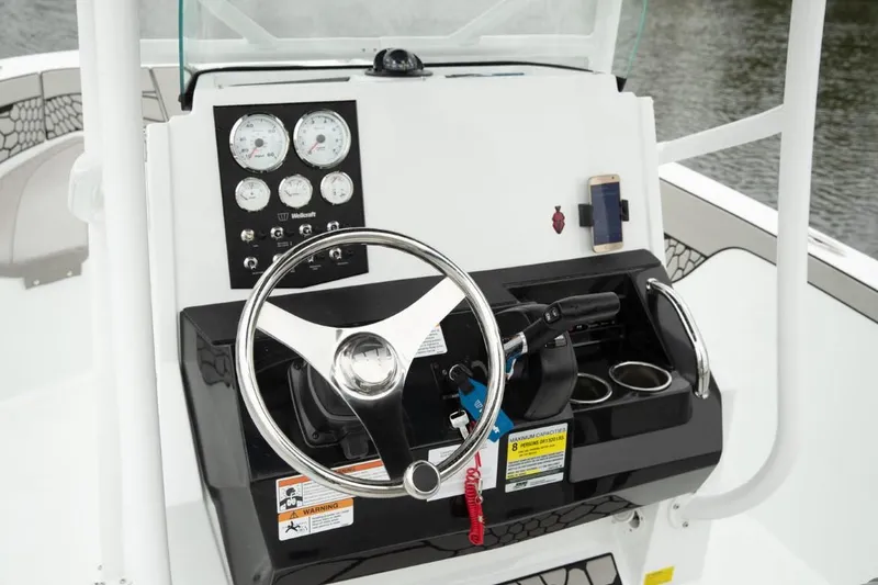 Slide: The Image of 2024 Wellcraft 202 Fisherman boat dashboard with steering wheel and control panel. - 18