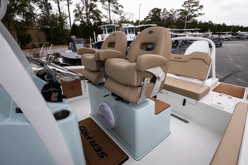 Slide: The Image of 2026 Sea Pro 245FLXR Sandbar boat interior with tan seating and steering wheel. - 12