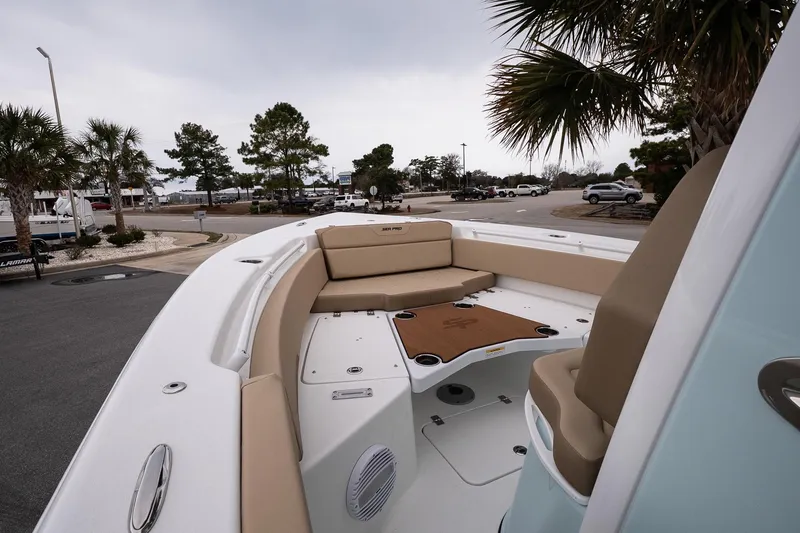 Slide: The Image of 2026 Sea Pro 245FLXR Sandbar boat interior with beige seating and palm trees in the background. - 15