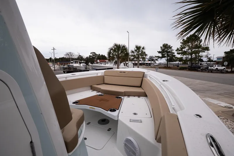 Slide: The Image of 2026 Sea Pro 245FLXR Sandbar boat with beige seating, docked near palm trees. - 17