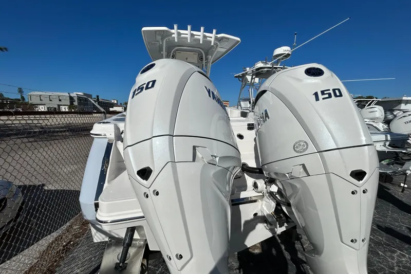 Slide: The Image of 2026 Robalo R250 Center Console with twin Yamaha 150 engines, docked outdoors. - 11