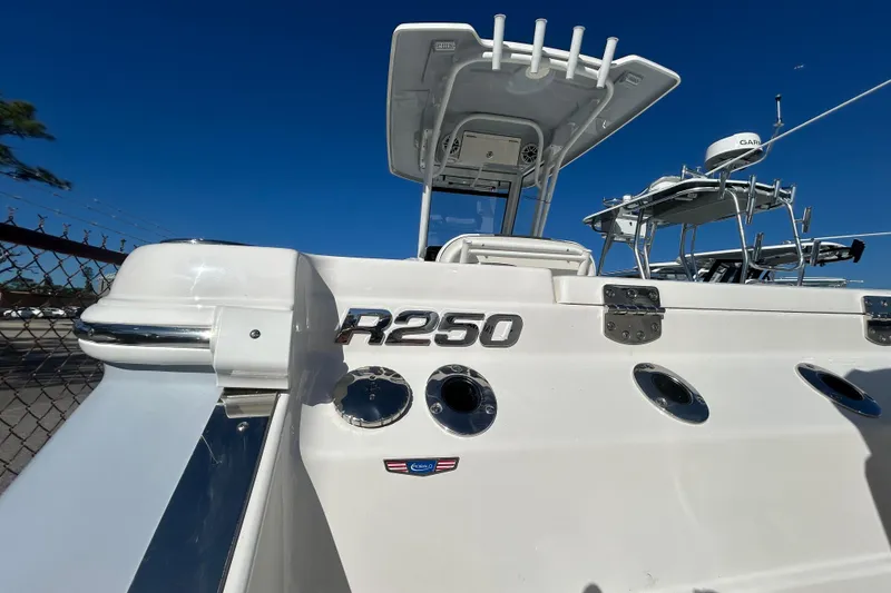 Slide: The Image of 2026 Robalo R250 Center Console boat, white exterior, docked under clear blue sky. - 29