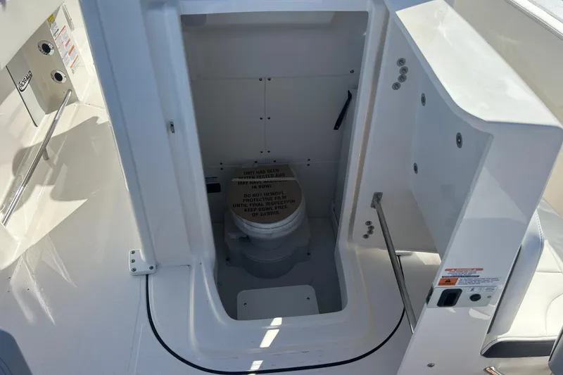 Slide: The Image of 2026 Robalo R250 Center Console boat interior with compact marine toilet. - 7