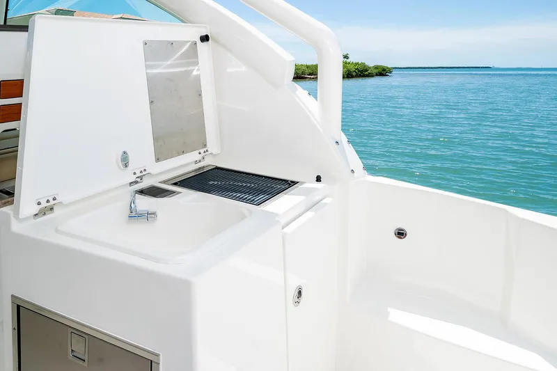 Slide: The Image of Pursuit DC 326 Dual Console 2021 with onboard kitchenette by the sea. - 11