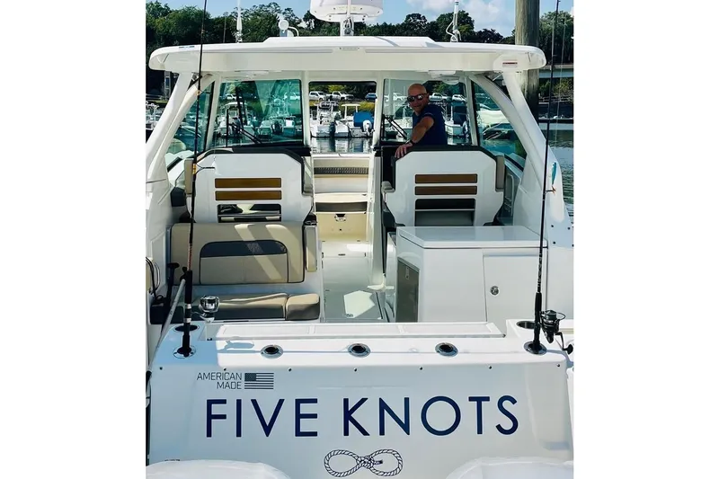 Slide: The Image of 2021 Pursuit DC 326 Dual Console boat named "Five Knots" docked at marina. - 3