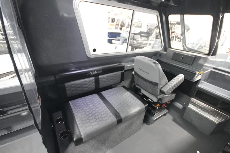 Slide: The Image of Interior of 2026 Weldcraft 240 Ocean King F300XCB boat, featuring seating and dashboard. - 23