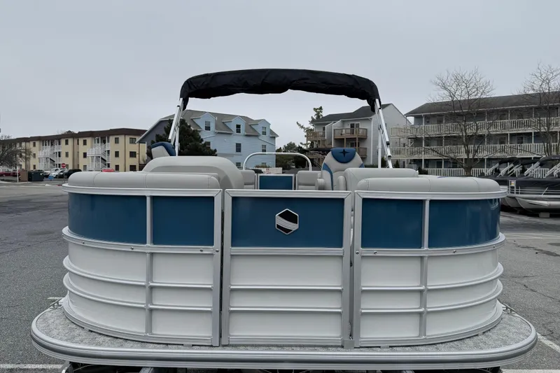 Slide: The Image of 2026 Berkshire 22RFX LE pontoon boat, blue and white, parked in a marina. - 3