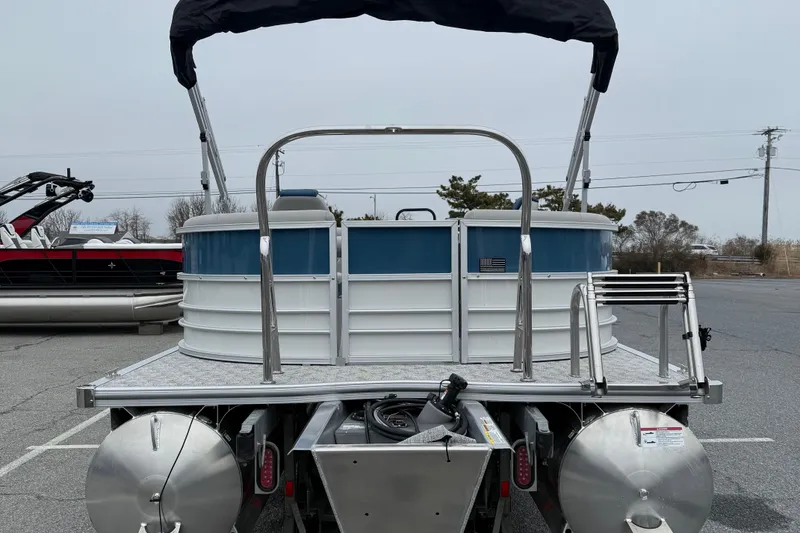 Slide: The Image of 2026 Berkshire 22RFX LE pontoon boat, rear view with ladder and canopy, parked outdoors. - 6