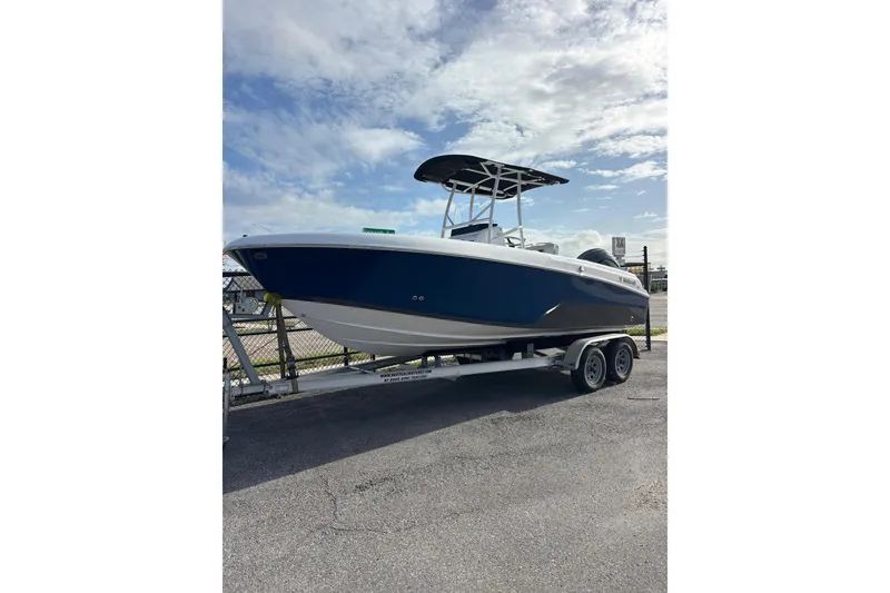 The Image of 2024 Wellcraft 202 Fisherman boat on trailer under a partly cloudy sky. - 0