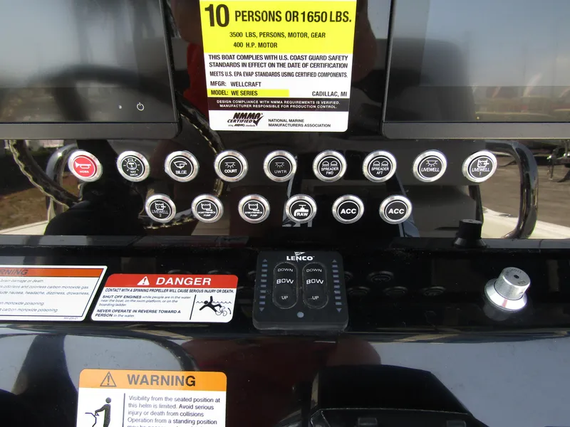 Slide: The Image of Control panel of 2024 Wellcraft 243 Fisherman boat with various switches and safety warnings. - 26