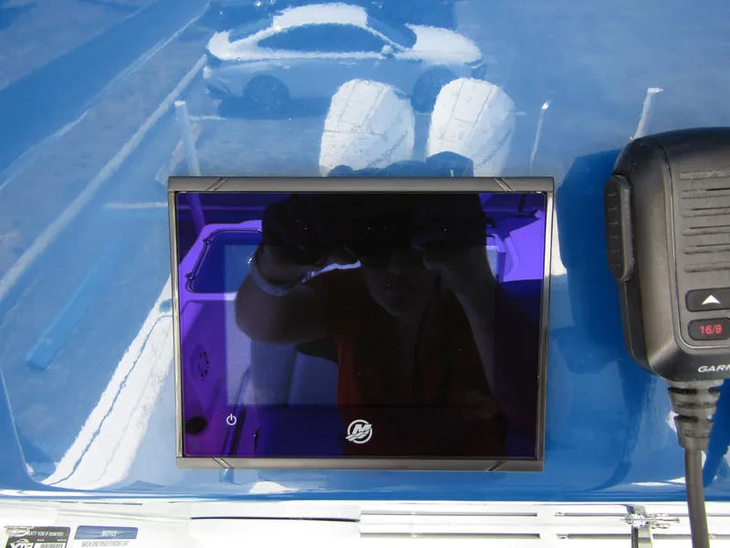 Slide: The Image of 2024 Wellcraft 243 Fisherman boat dashboard with Garmin display and radio. - 22