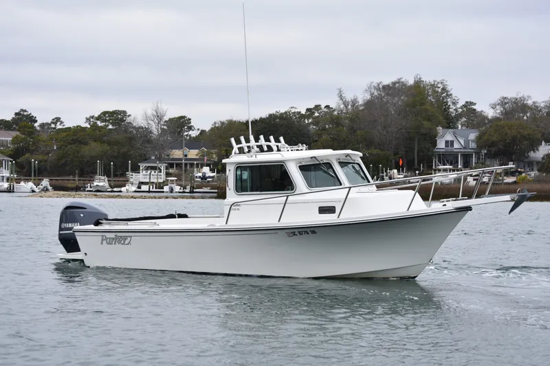 The Image of 2015 Parker 2320 SL Sport Cabin boat cruising on a calm waterway. - 0
