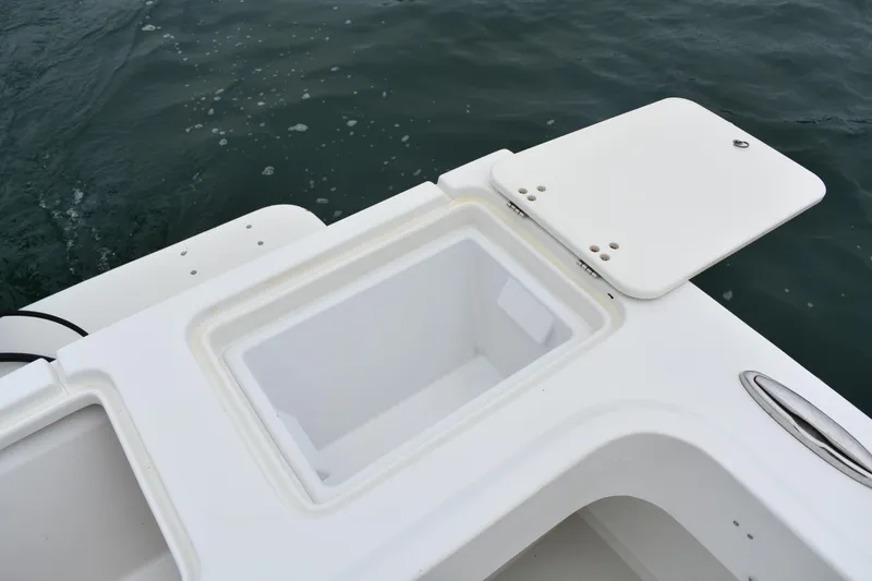 Slide: The Image of Open storage compartment on 2015 Parker 2320 SL Sport Cabin boat, near water. - 12