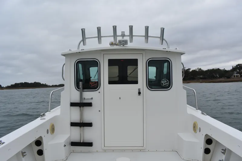 Slide: The Image of 2015 Parker 2320 SL Sport Cabin boat on water, rear view, overcast sky. - 16