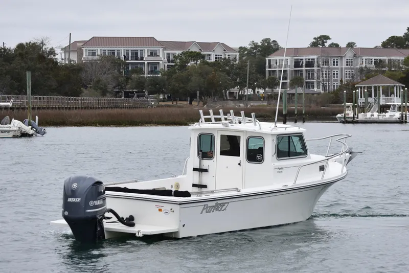 Slide: The Image of 2015 Parker 2320 SL Sport Cabin boat on water near residential area. - 2