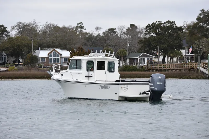 Slide: The Image of 2015 Parker 2320 SL Sport Cabin boat on water near shoreline homes. - 3