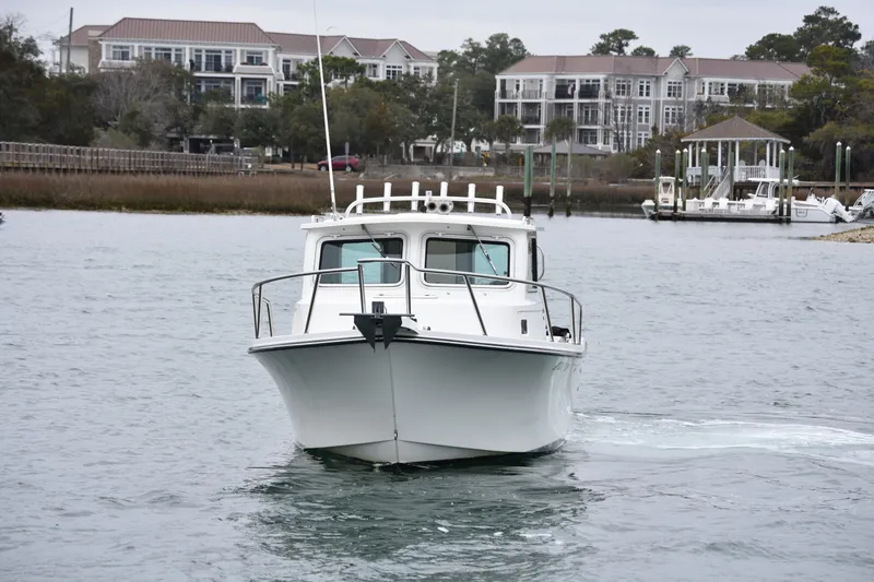 Slide: The Image of 2015 Parker 2320 SL Sport Cabin boat on water near residential area. - 5