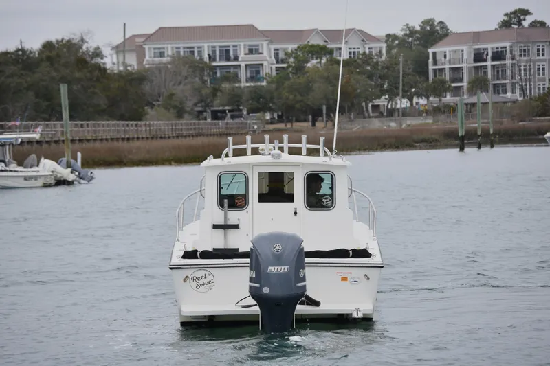 Slide: The Image of 2015 Parker 2320 SL Sport Cabin boat on water near residential area. - 6