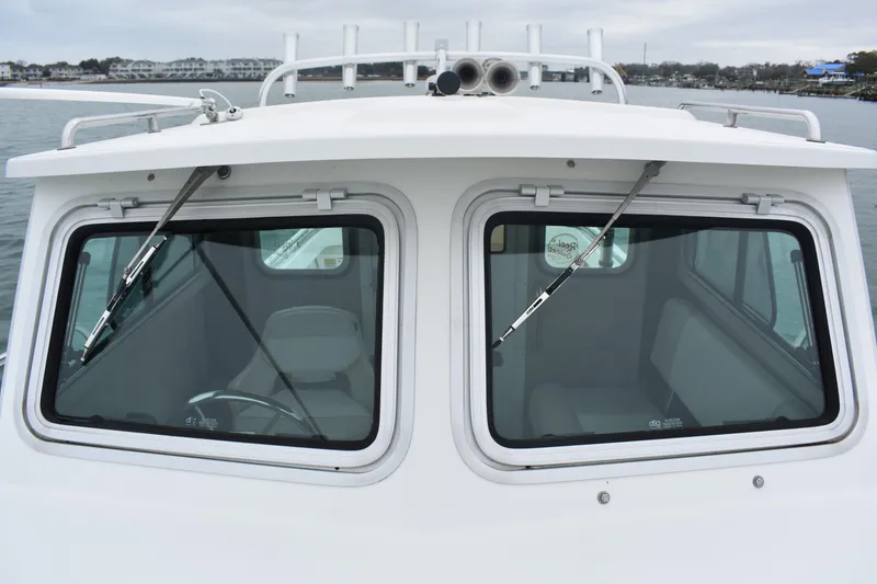 Slide: The Image of 2015 Parker 2320 SL Sport Cabin boat with dual windshield wipers on calm water. - 9