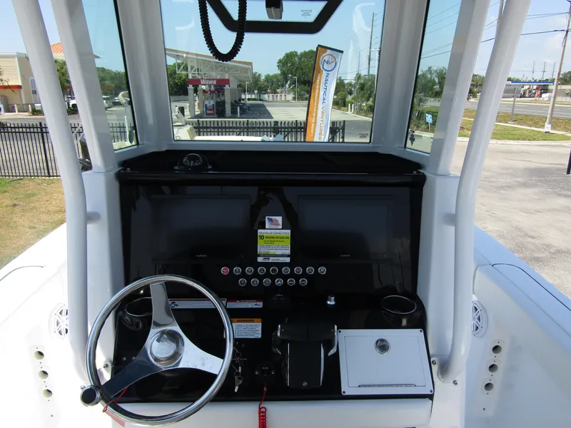 Slide: The Image of 2024 Wellcraft 243 Fisherman boat dashboard with steering wheel and control panel. - 20