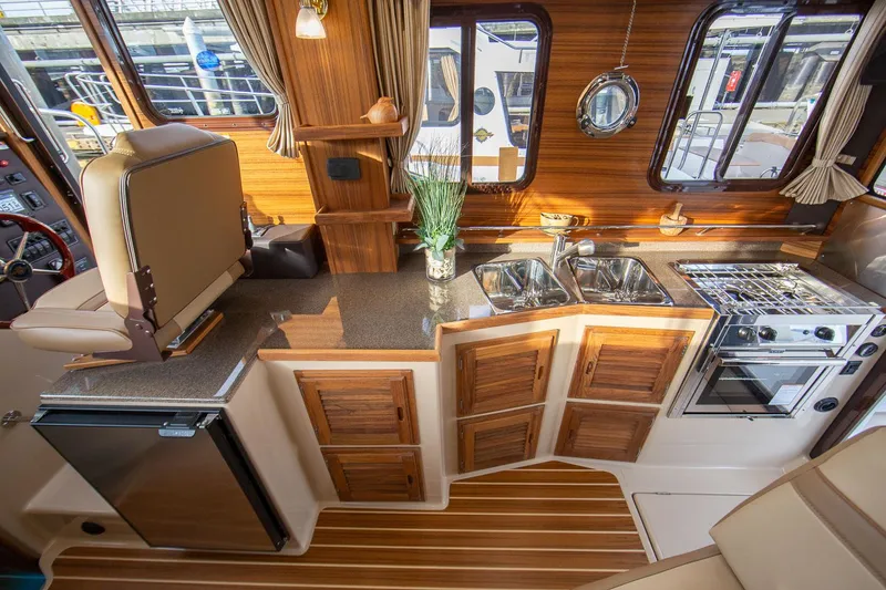 Slide: The Image of Manufacturer Provided Image: Luxurious 2025 Ranger Tugs R-31 CB interior with modern kitchen and wood accents. - 14