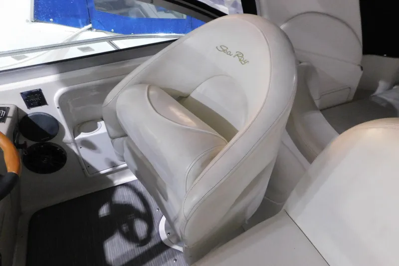 Slide: The Image of Captain's seat in 2002 Sea Ray 340 Sundancer boat cockpit, featuring white leather upholstery. - 12