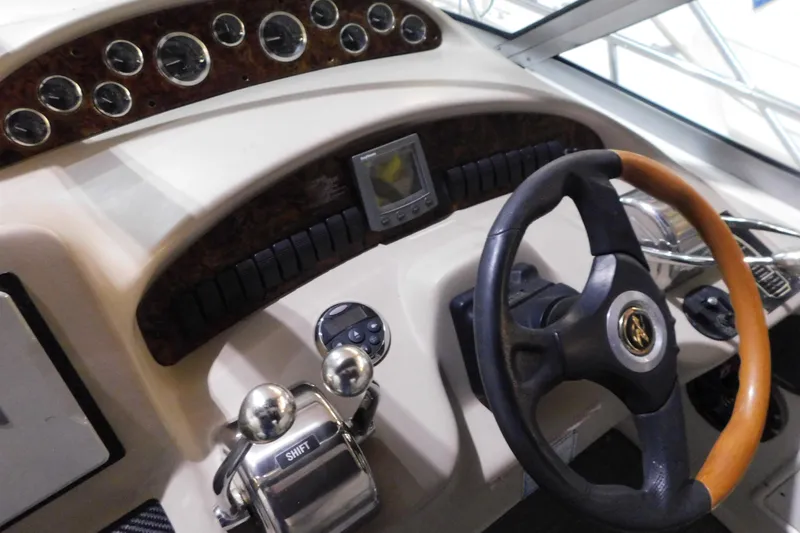 Slide: The Image of 2002 Sea Ray 340 Sundancer helm with gauges, steering wheel, and controls. - 14