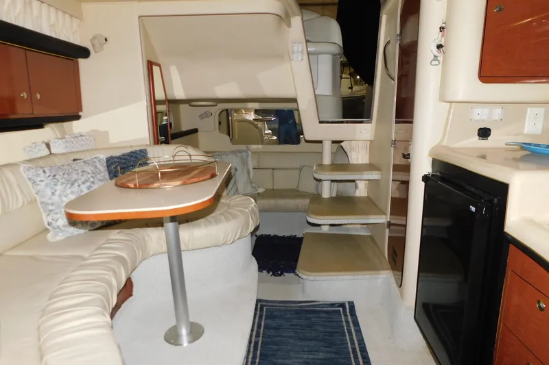 Slide: The Image of Interior of 2002 Sea Ray 340 Sundancer yacht with seating, table, and kitchenette. - 24