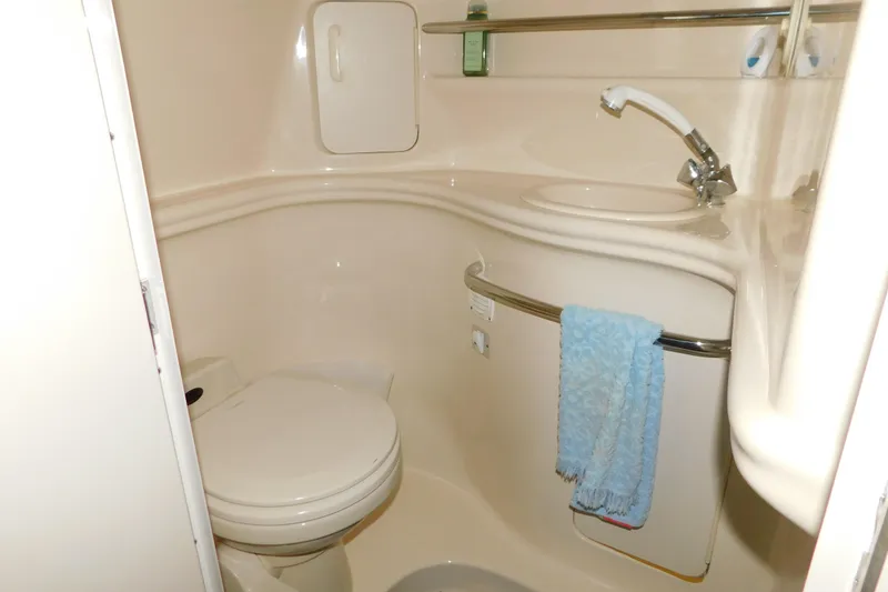 Slide: The Image of Compact bathroom in 2002 Sea Ray 340 Sundancer yacht with sink, toilet, and towel. - 26